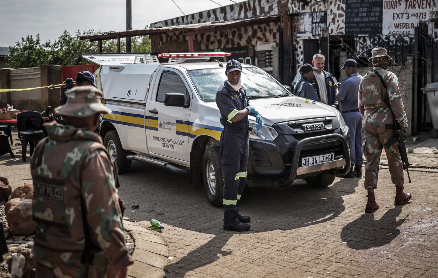 Members of South Africa’s Forensic Pathology Service and the South African National Defence Force at the scene of Sunday’s shooting near Johannesburg.